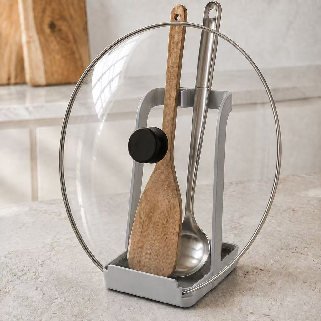 White kitchen stand holding a pot lid, spoon and spatula