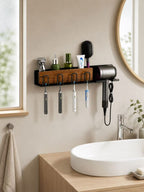 Black wall-mounted bathroom organizer holding toothbrushes, grooming tools and a hair dryer above a vanity